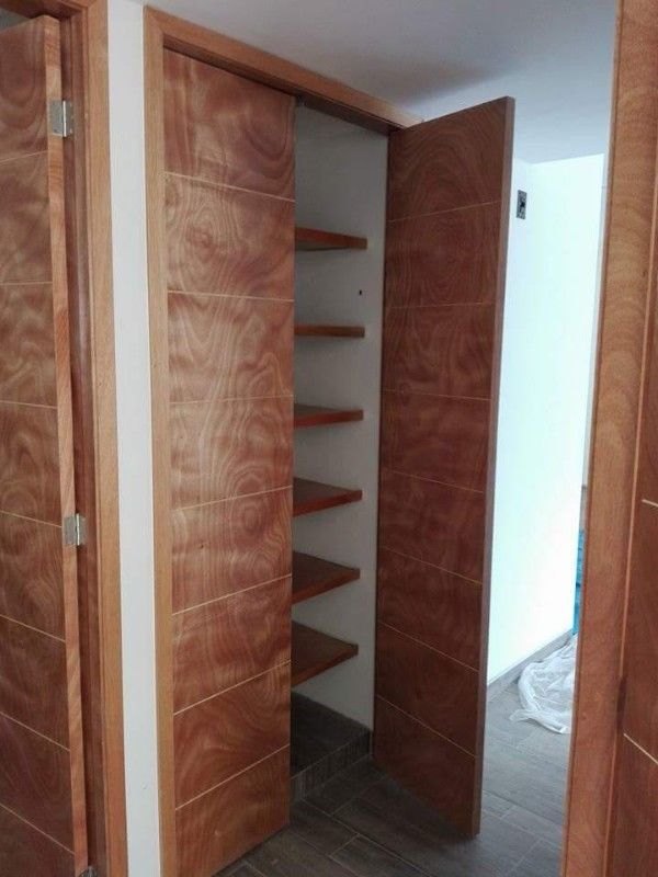 Clóset con puertas de madera veteada y entrepaños