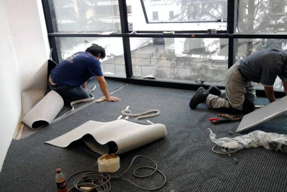 Instaladores de Spazio colocando alfombra en una oficina
