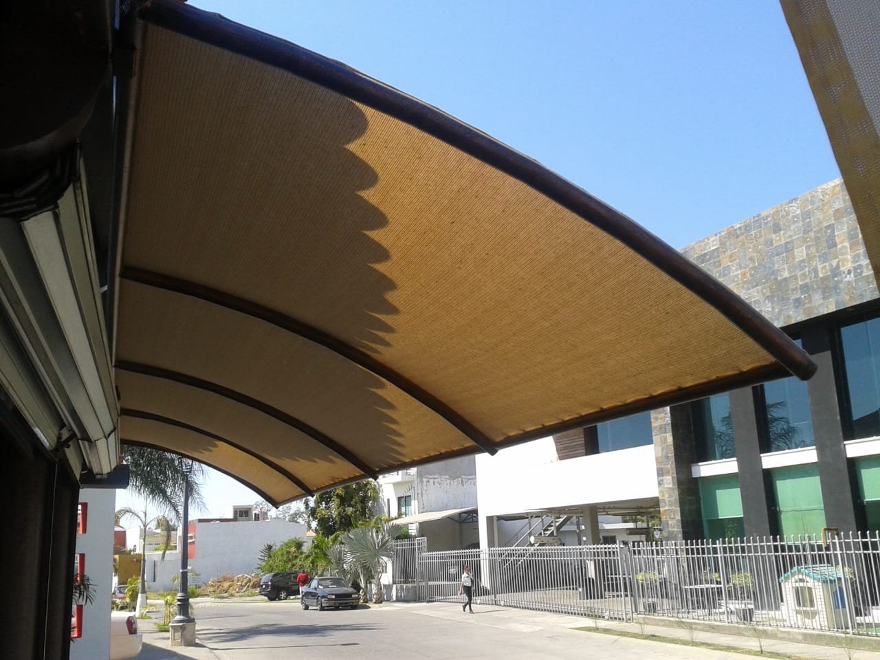 Cochera con toldo fijo semicurvo en lona café