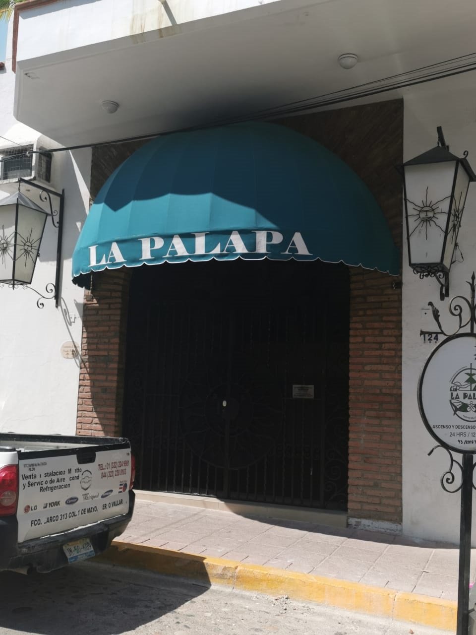Toldo fijo de media naranja sobre el acceso de un restaurante