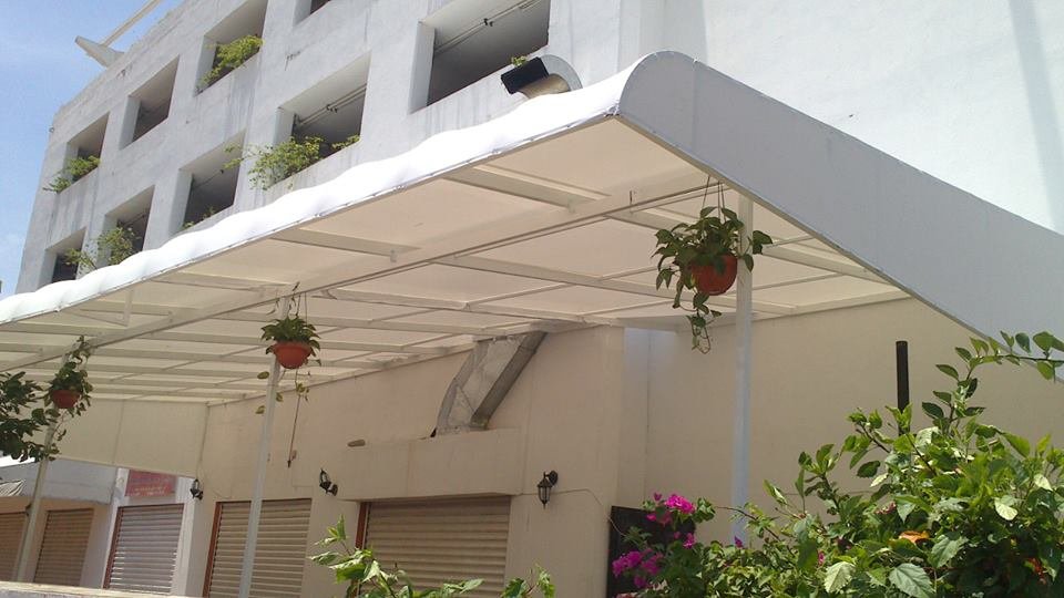 Pérgola fija con lona blanca cubriendo un patio interior