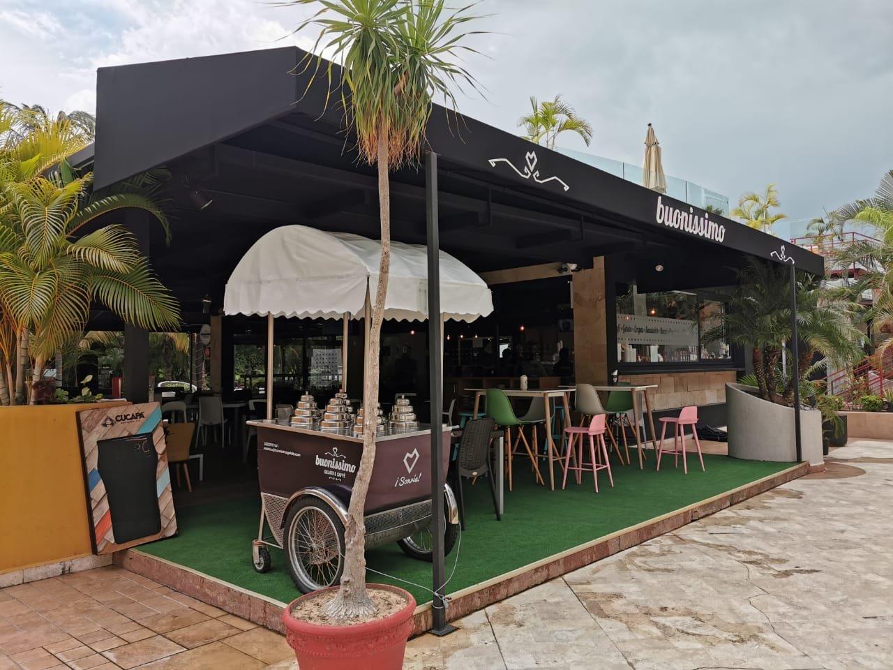 Toldo fijo de un agua cubriendo la terraza de un restaurante en esquina